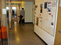 photo of corridor leading to office, bulletin board on right